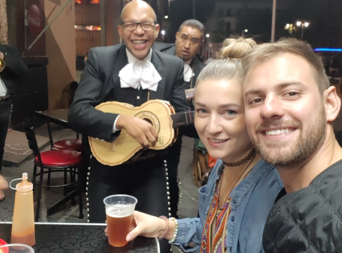 couple takes a selfie with a mariachi music player in Mexico City