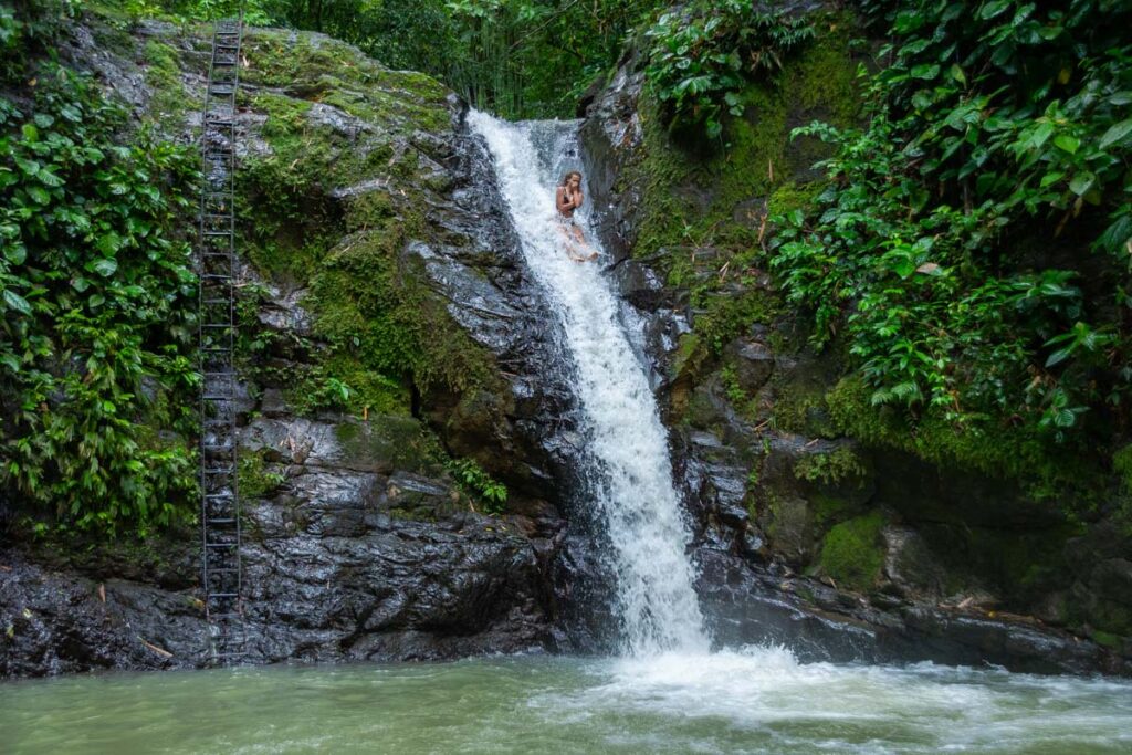 A lady slides down Uvita Waterfall