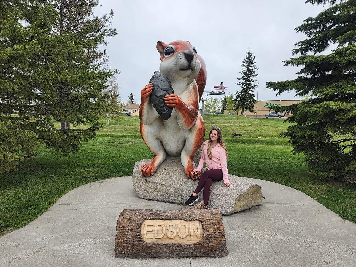 woman takes a picture with the giant squirrel in Edson, Alerta