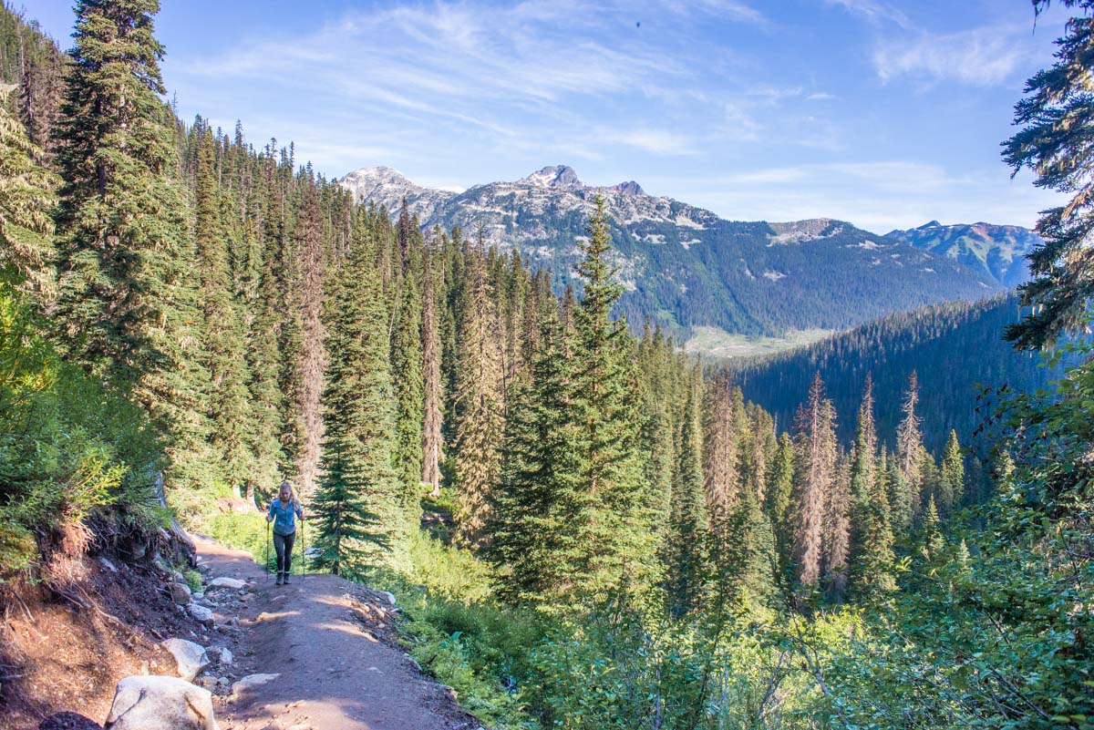Joffre Lakes Trail views of the valley and mountains as a lady walks up the trail