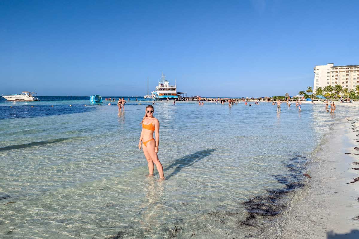 Bailey stands in the shallow and calm waters of Playa Langosta in Cancun, Mexico