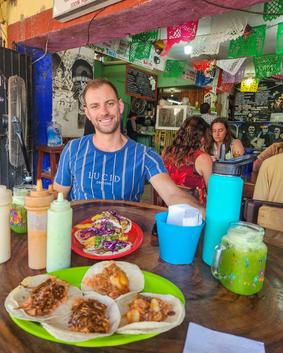 Daniel sits down to eat tacos at Mr. Taco, Bacalar