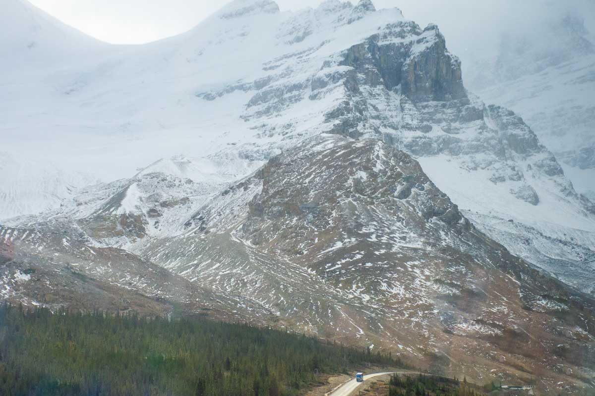 An all terrain vehicle drives along the road to the Athabasca Glacier