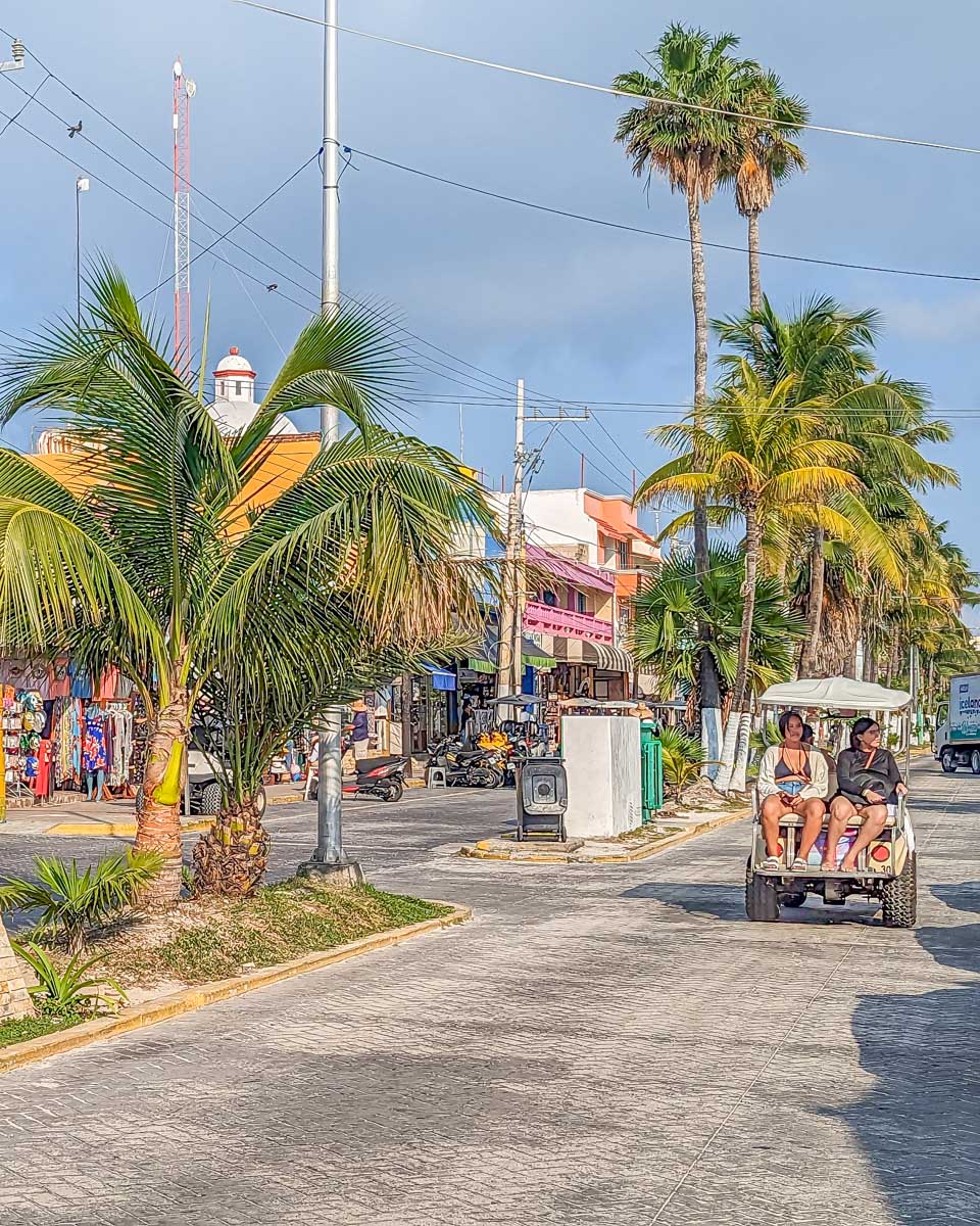 A golf buggy drives along a road on Isla Mujeres, Mexico