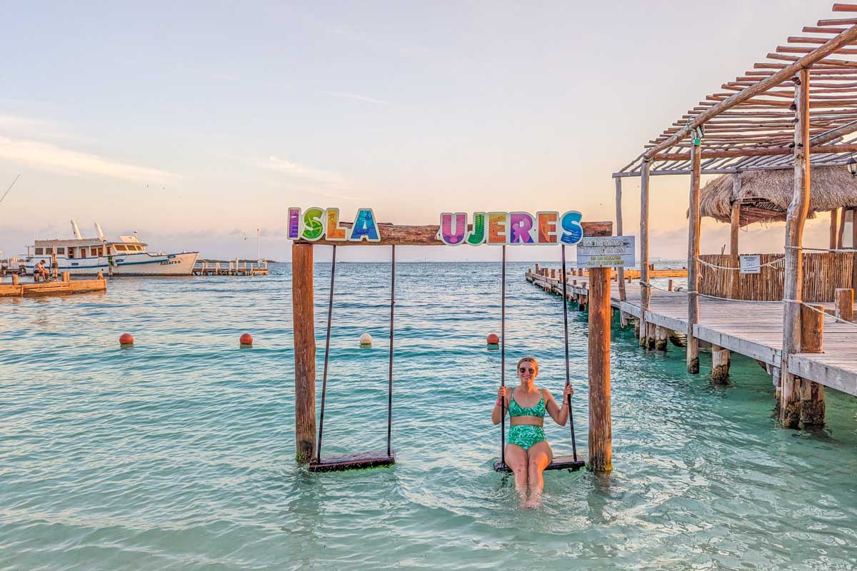 Bailey relaxing on the swings at Playa Centro, Isla Mujeres at sunset