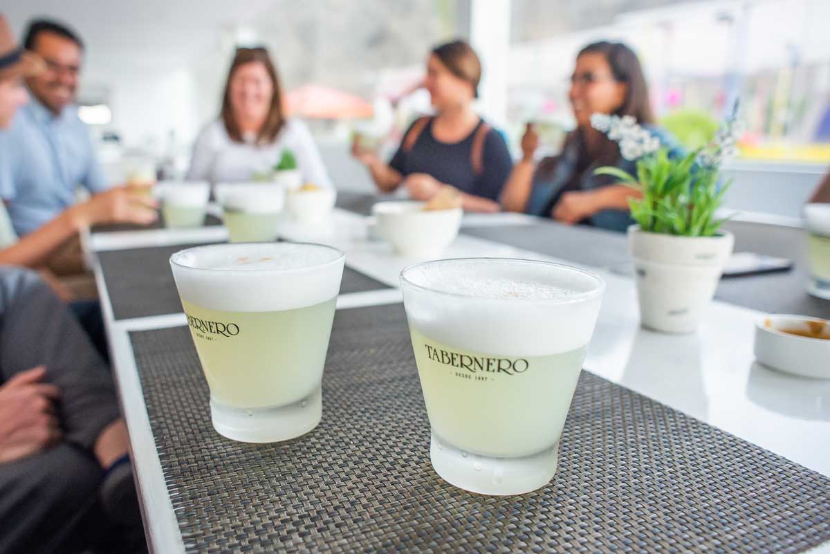 Two pisco sours on a table while tasting Pisco in Lima, Peru