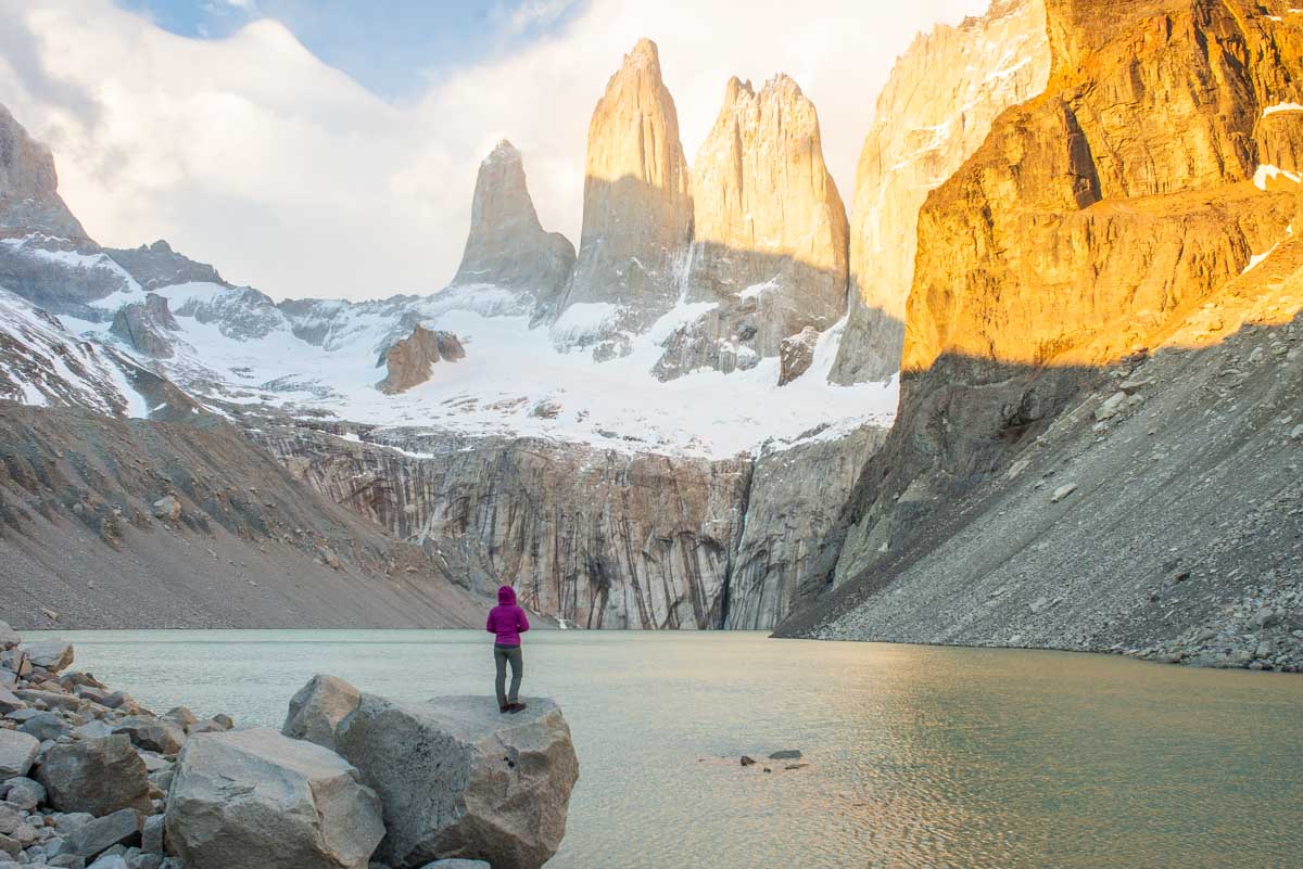 A lady stands on a rock during sunrise at Mirador Las Torres