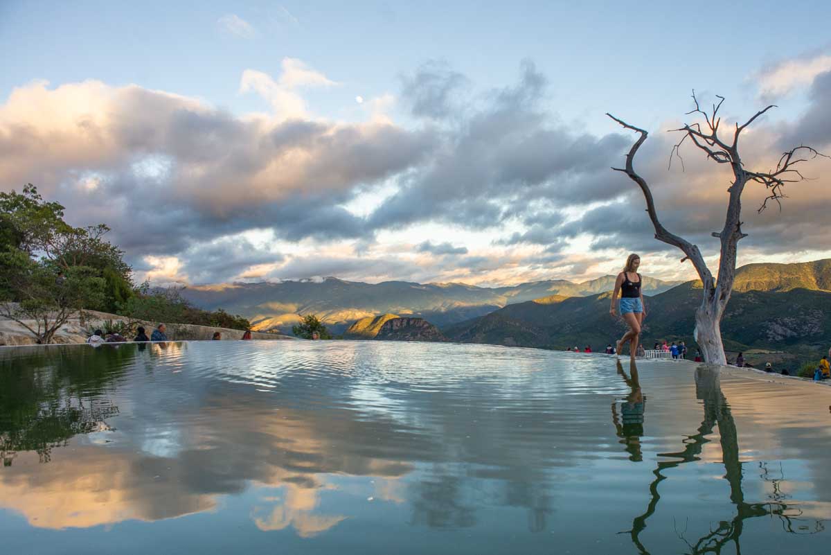 Bailey walks along the edge of a pool at Hierve El Agua in Oaxaca, Mexico at sunset