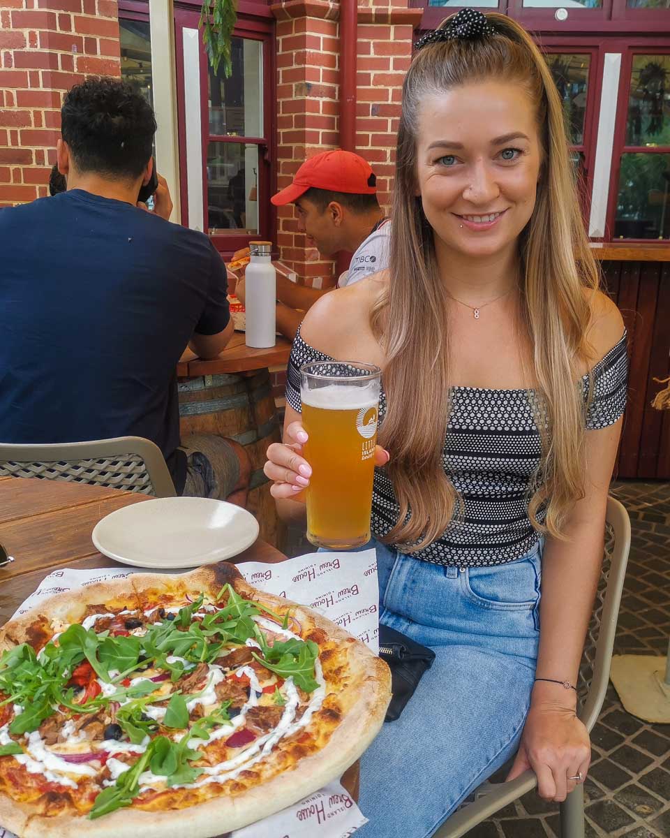 Bailey with a beer and pizza at The Island Brew House in Elizabeth Quay, Perth