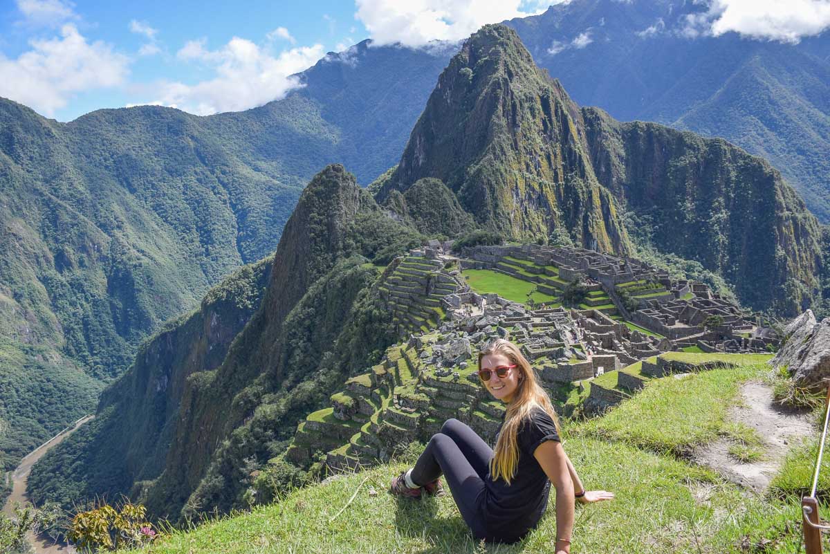 Bailey sits on a ledge while overlooking the main area of Machu Picchu Inca ruins in Peru