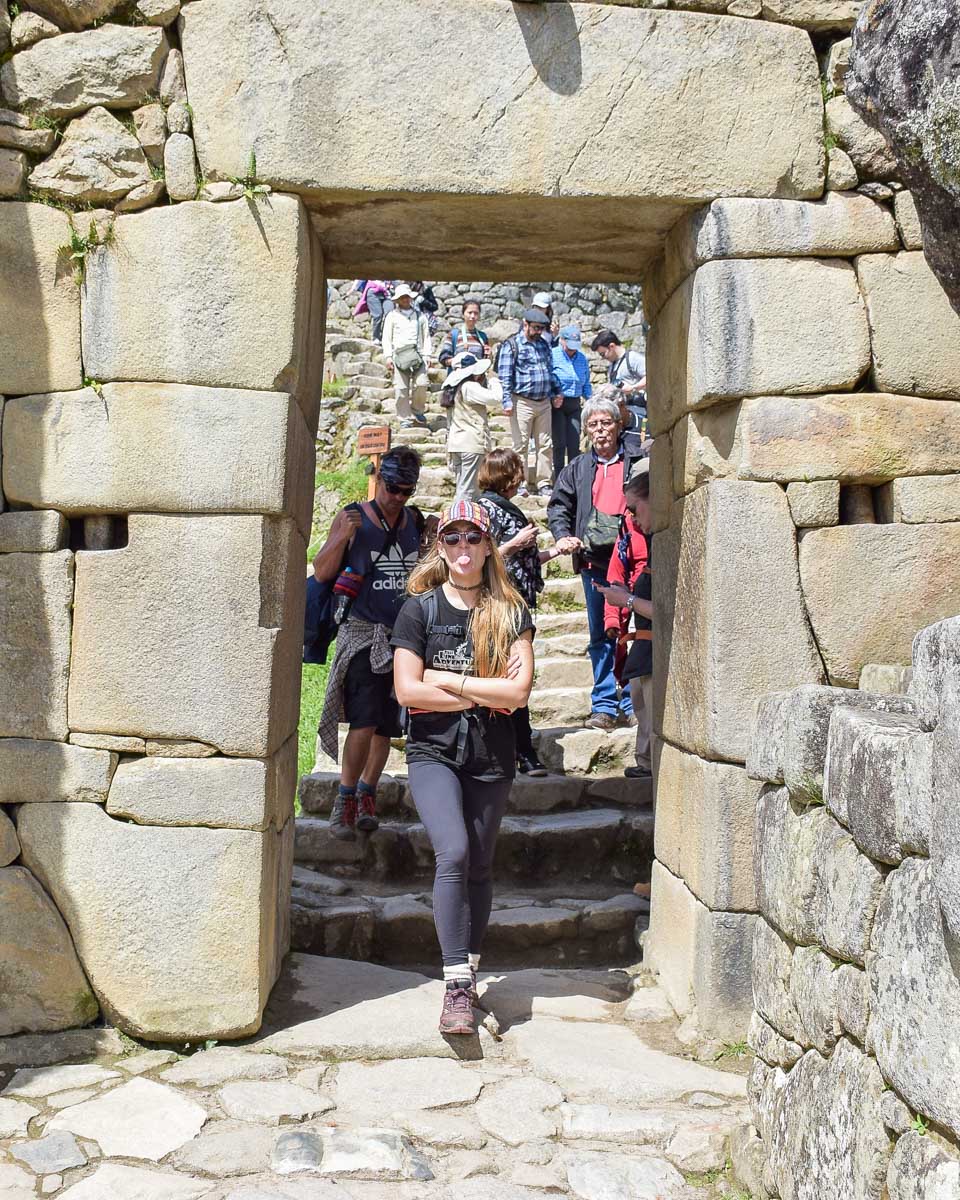 Bailey walks through a stone doorway at Machu Picchu on a guided tour