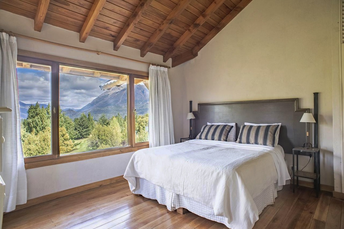a bed in a beautiful luxury hotel room with mountain views from the window
