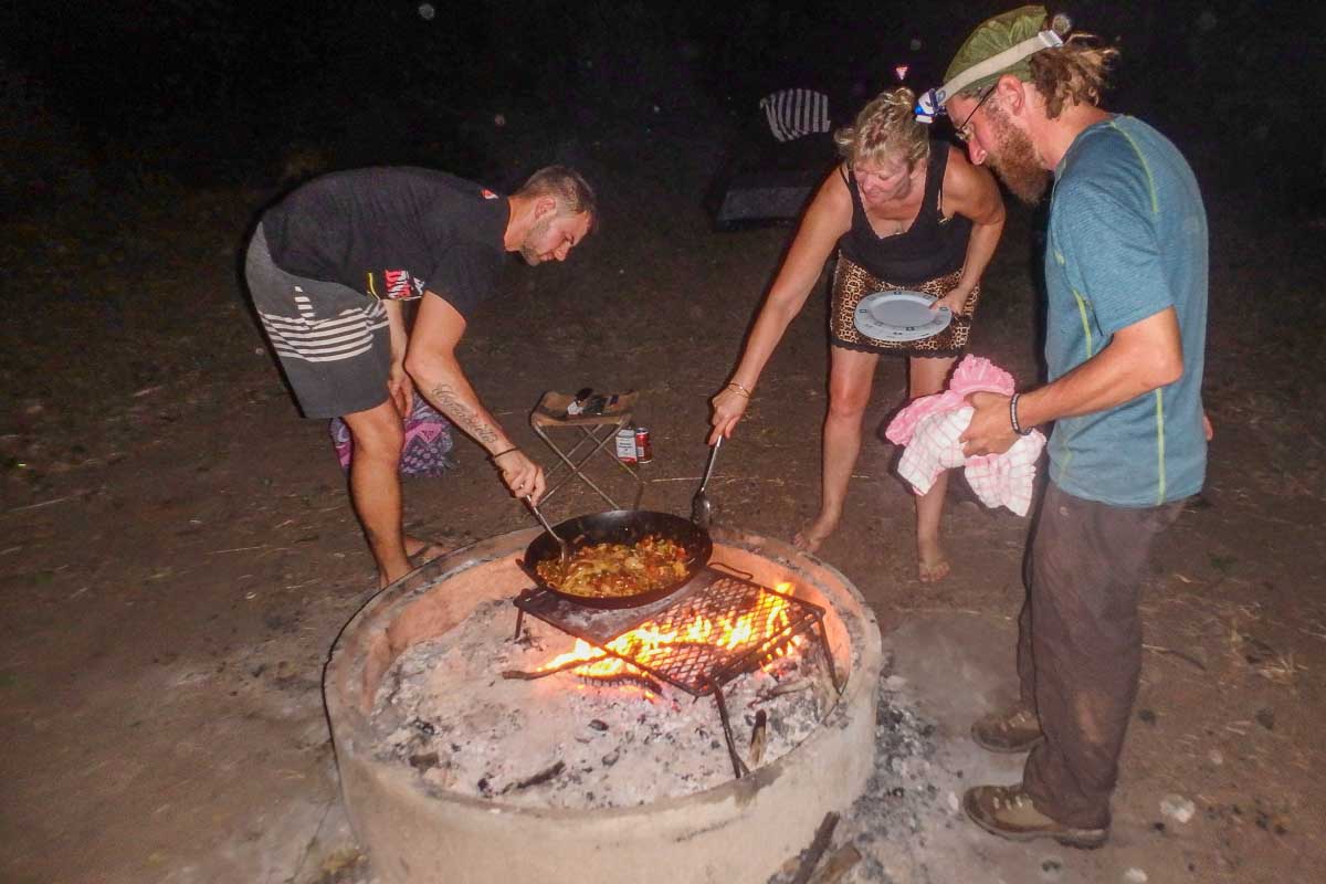 A group of people cook over a fire at a campsite in Kakadu National Park