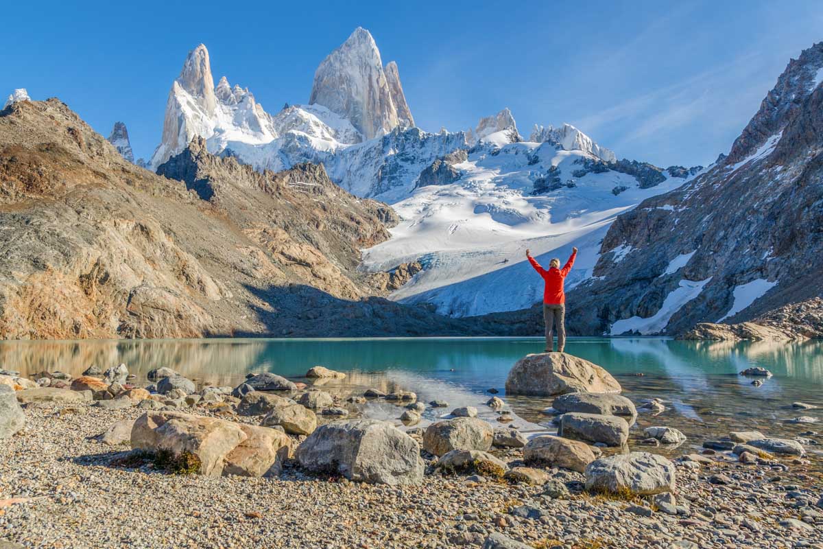 A lady stands at the egde of Laguna De Los Tres on the Mount Fitz Roy Hike in El Chalten, Patagonia