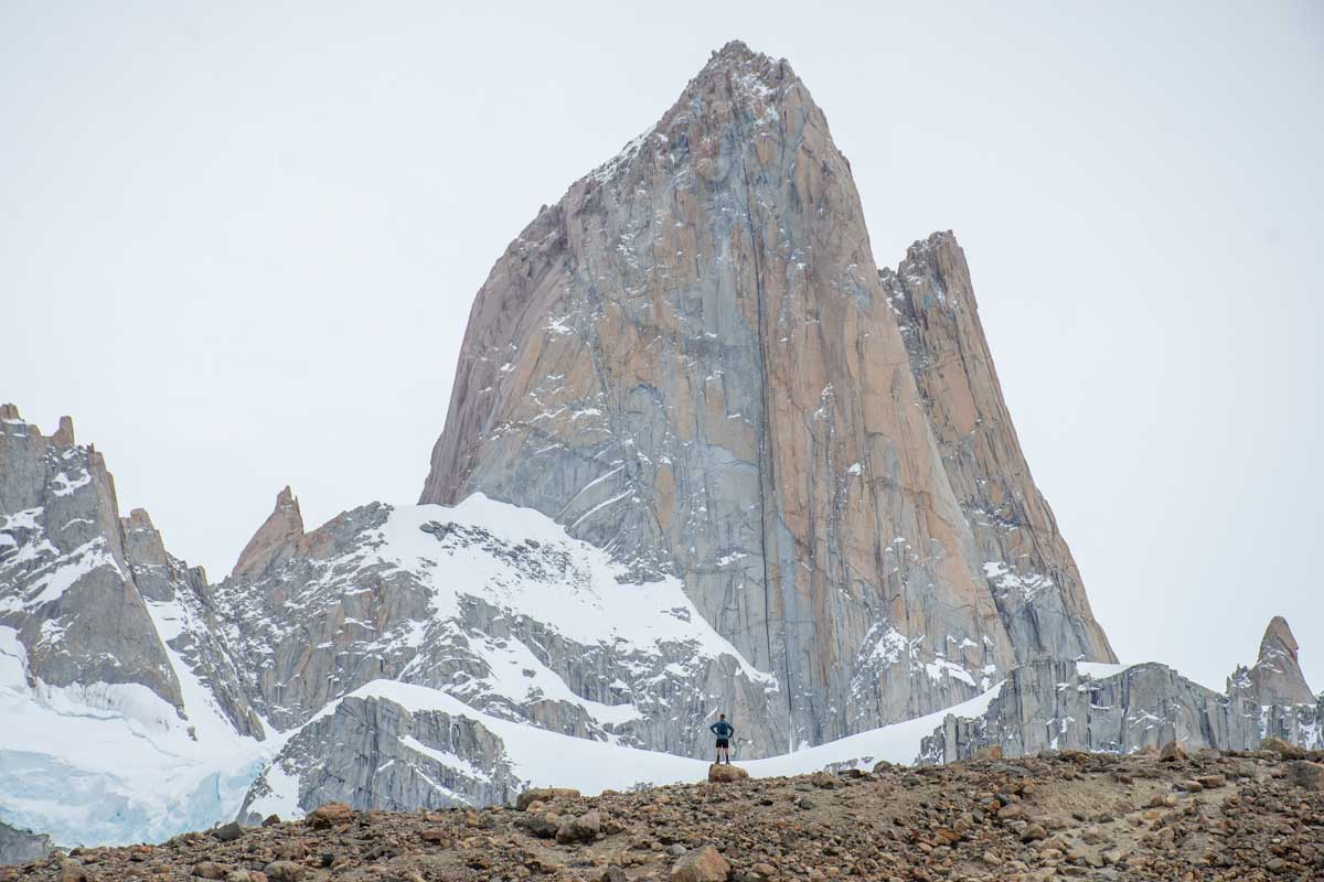 A man stands under Mount Fitz Roy