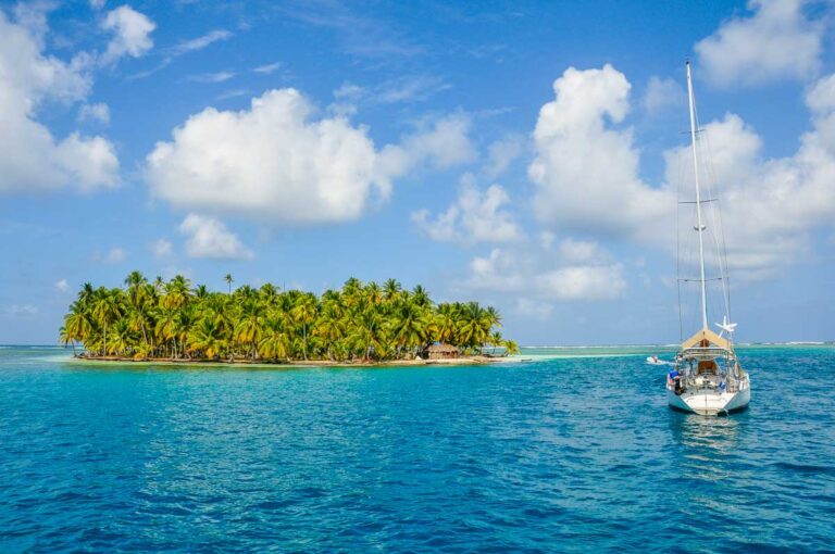 A yacht sails past a small island in the San Blas Islands, Panama