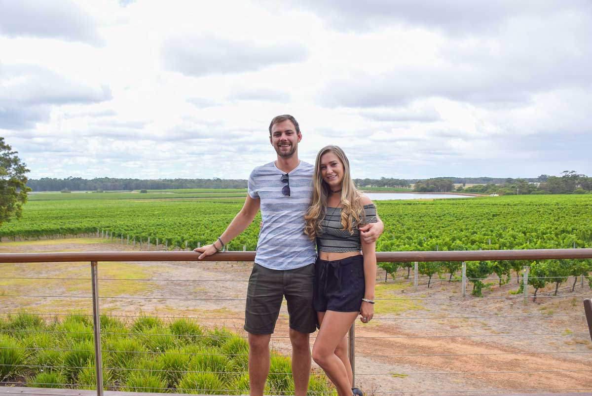 Daniel and Bailey pose for a photo at a winery in Margaret River with vines in the background