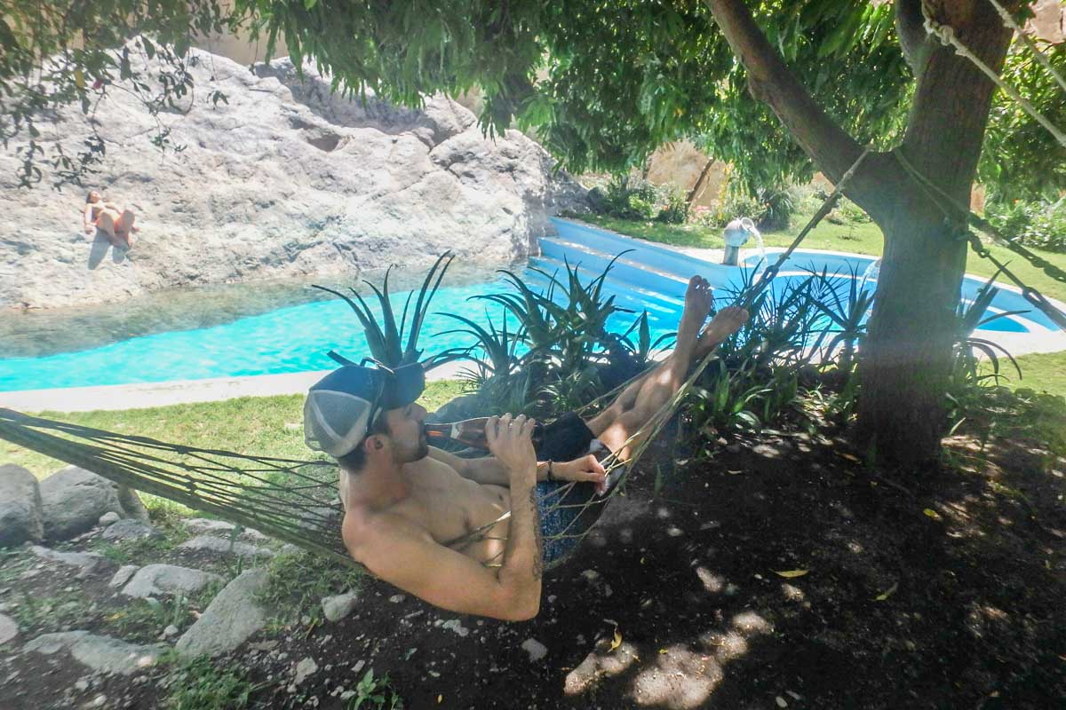 Daniel relaxes in a hammock in Colca Canyon with a beer