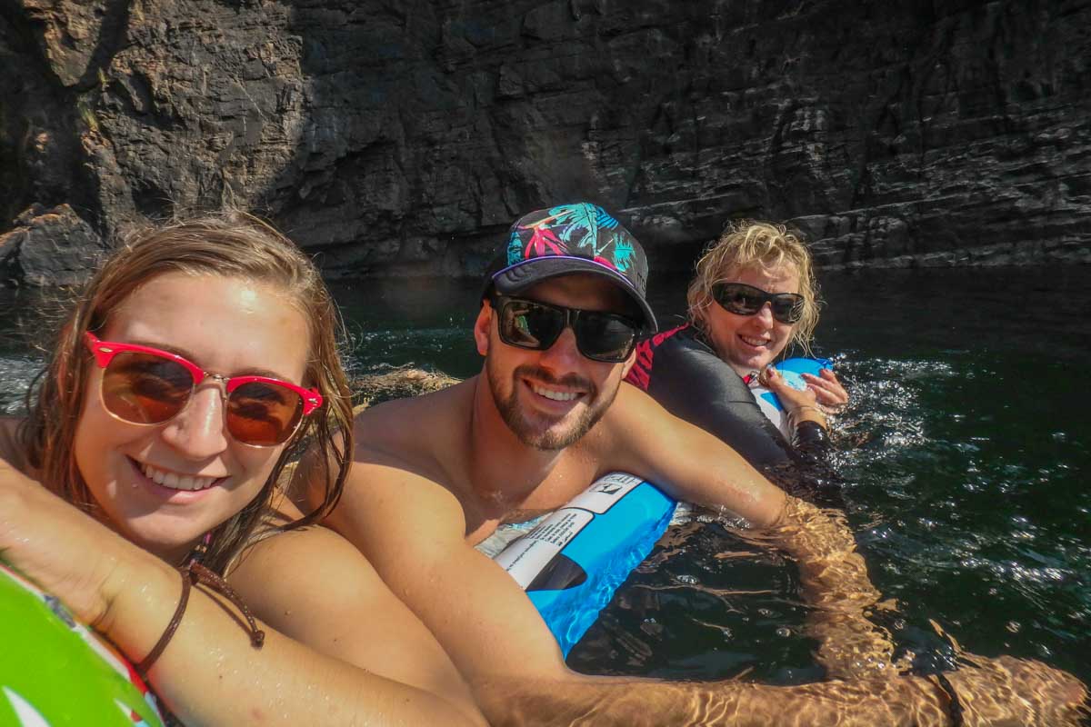 Three people float in Barramundi Gorge, Kakadu National Park