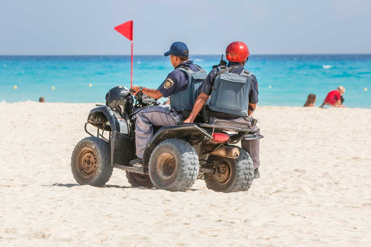 Police on an ATV patrol the beach in Cancun, Mexico