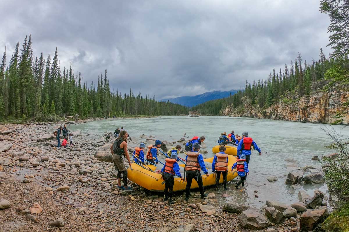 A group of tourists launch a raft with a guide in Jasper, Canada