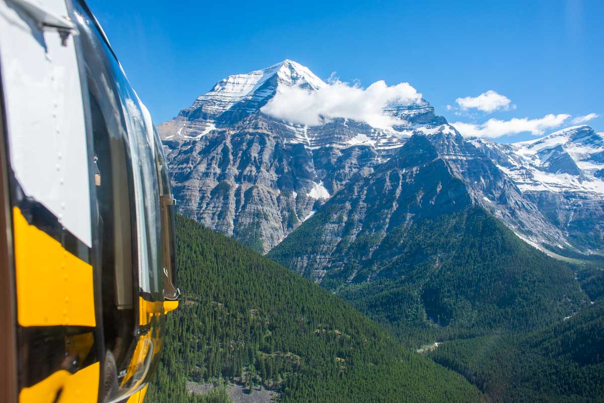 A helicopter flies into Mount Robson Provicial Park with views of Mount Robson