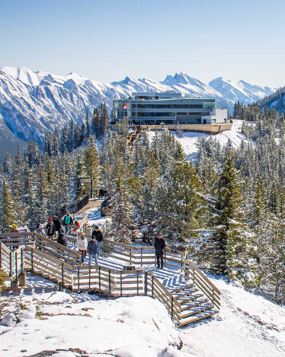 Banff gondola building and boardwalk on a early spring day with lots of snow
