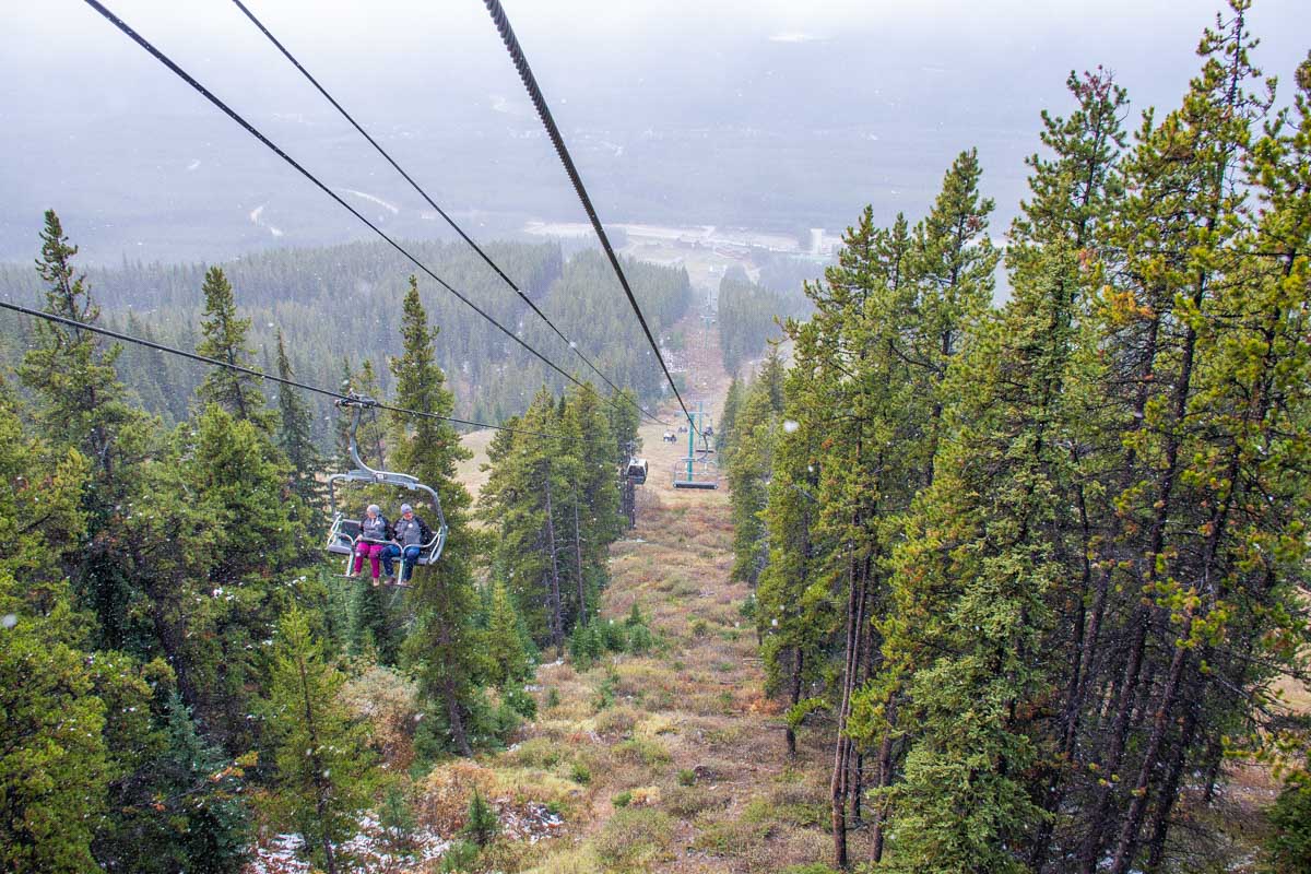 Lake Louise sightseeing gondola on a cloudy day in summer with some snow