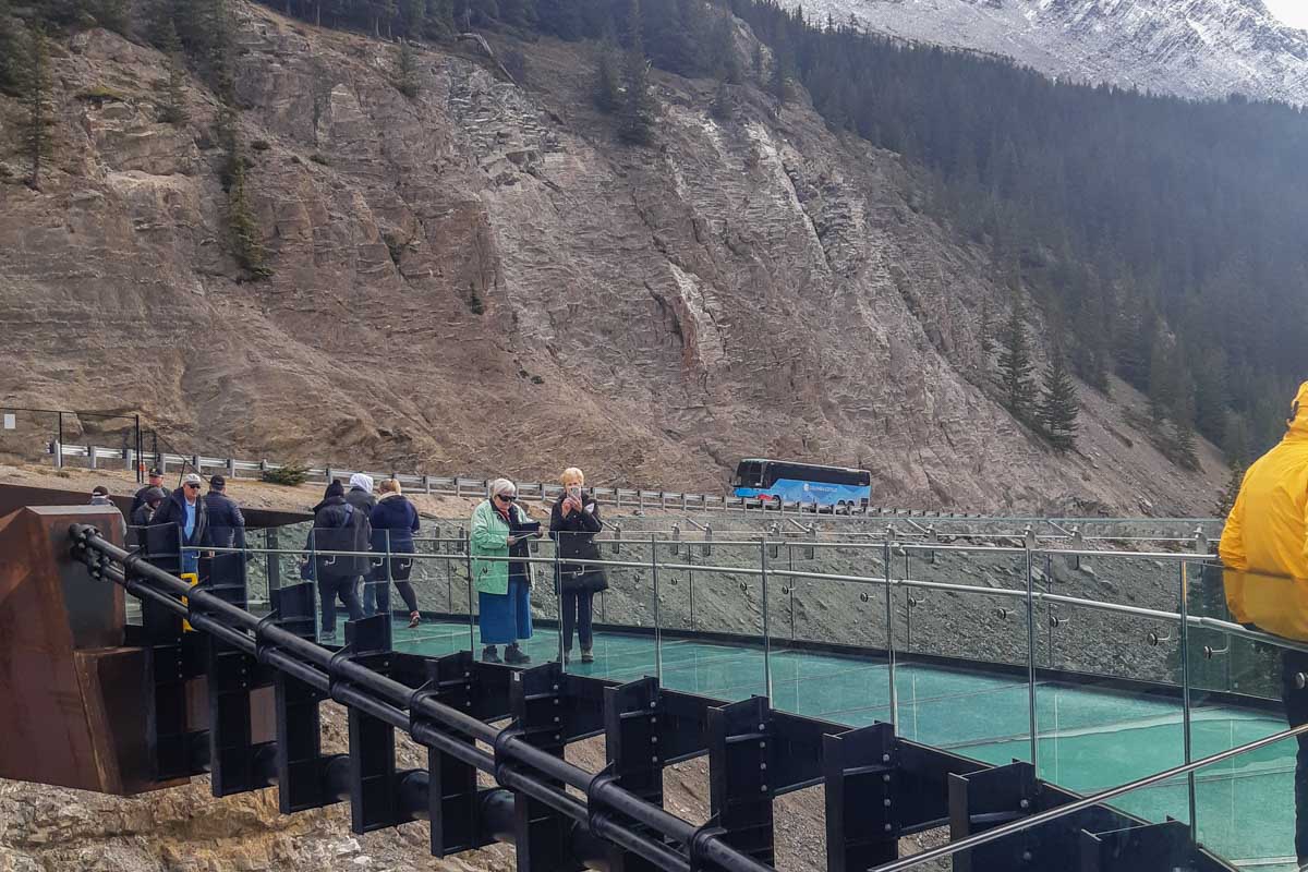 People walk on the glass floor on the Columbia Icefield Skywalk in Banff National Park
