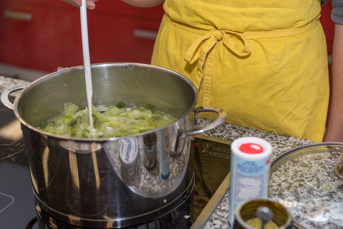 lady cooks soup in a close up of the pot