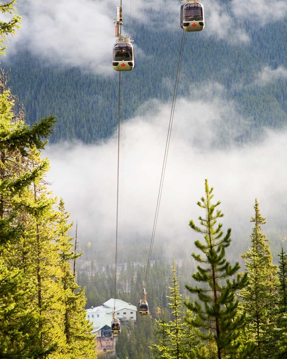 fours cars some up the cable of the Banff Gondola with mountain views
