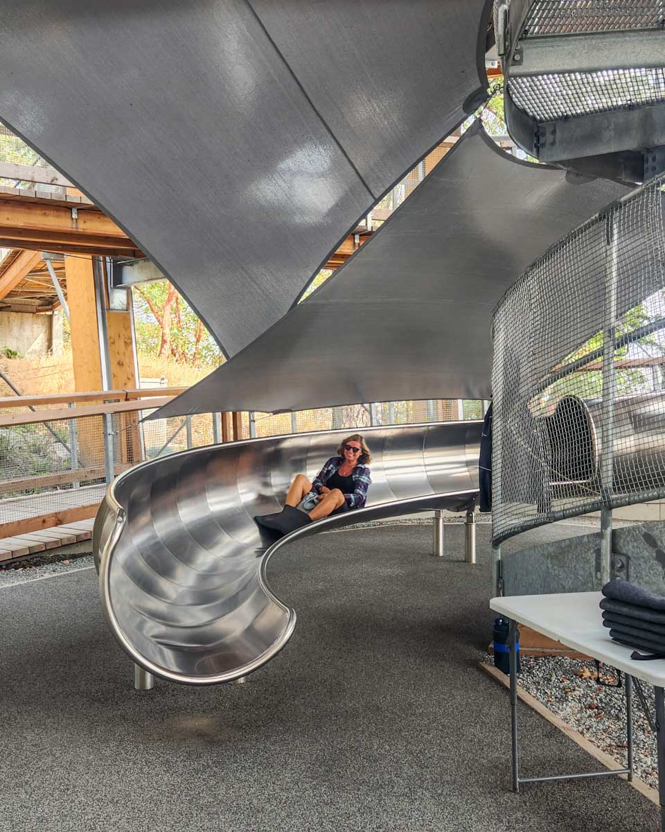 A lady comes down the slide at the Malahat Skywalk in Malahat, British Columbia