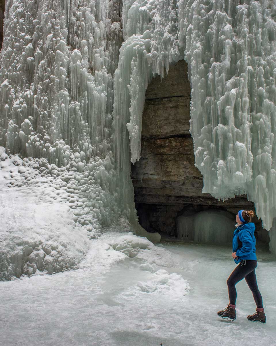 Bailey walking over the Maligne Canyon ice looking at a frozen waterfall