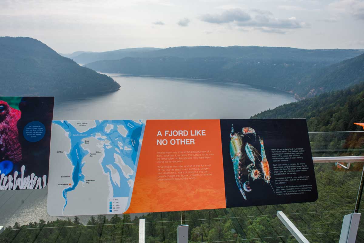 Signs with a view at the top of the Malahat Skywalk in Malahat, British Columbia