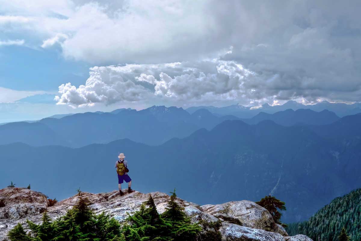 a man takes a photo at the top of Mount Seymour in Vancouver, Canada