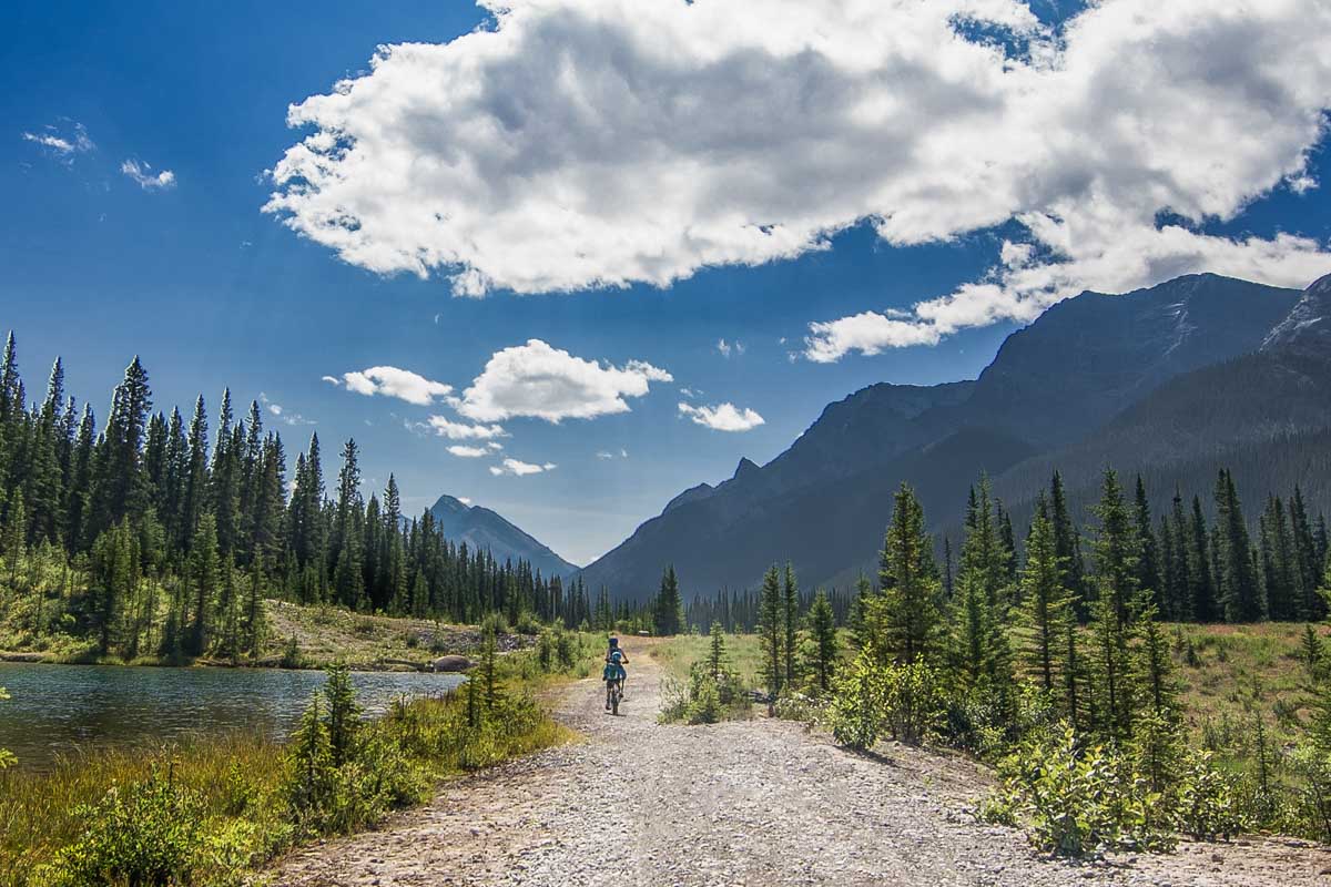 A group of people ride their bikes on a trail near Canmore