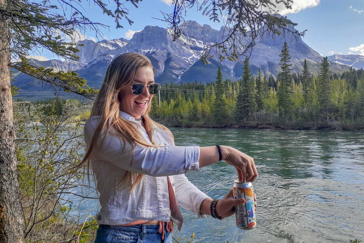 Bailey cracks a beer along the Bow River in Canmore, Alberta