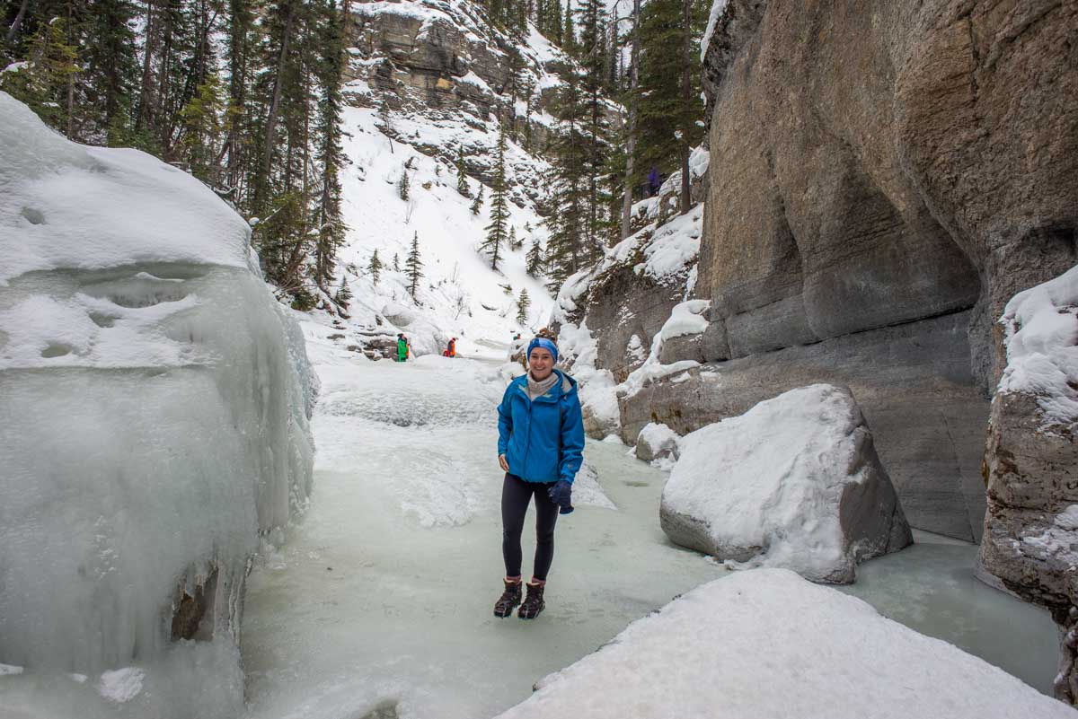 Bailey smiles at the camera as she walks through Maligne Canyon in Jasper National Park during winter