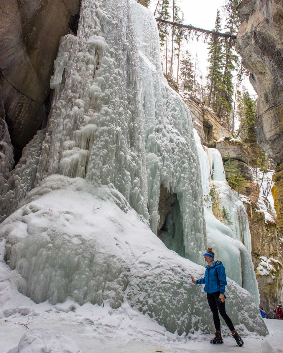 Bailey walks past a frozen waterfall as she explores Maligne Canyon in Winter