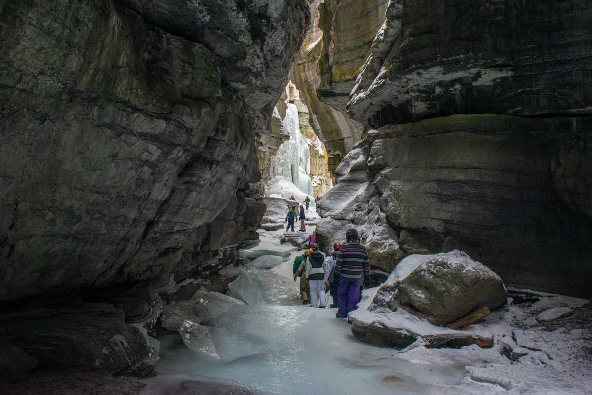 Bailey walks through the steep canyon walls on the ice in Maligne Canyon