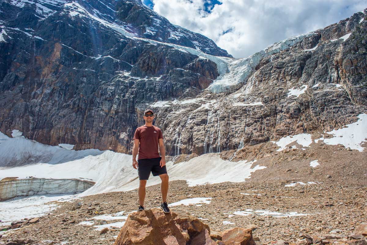 Daniel stands on a rock below Mount Edith Cavell and the Edith Cavell Glacier in Jasper