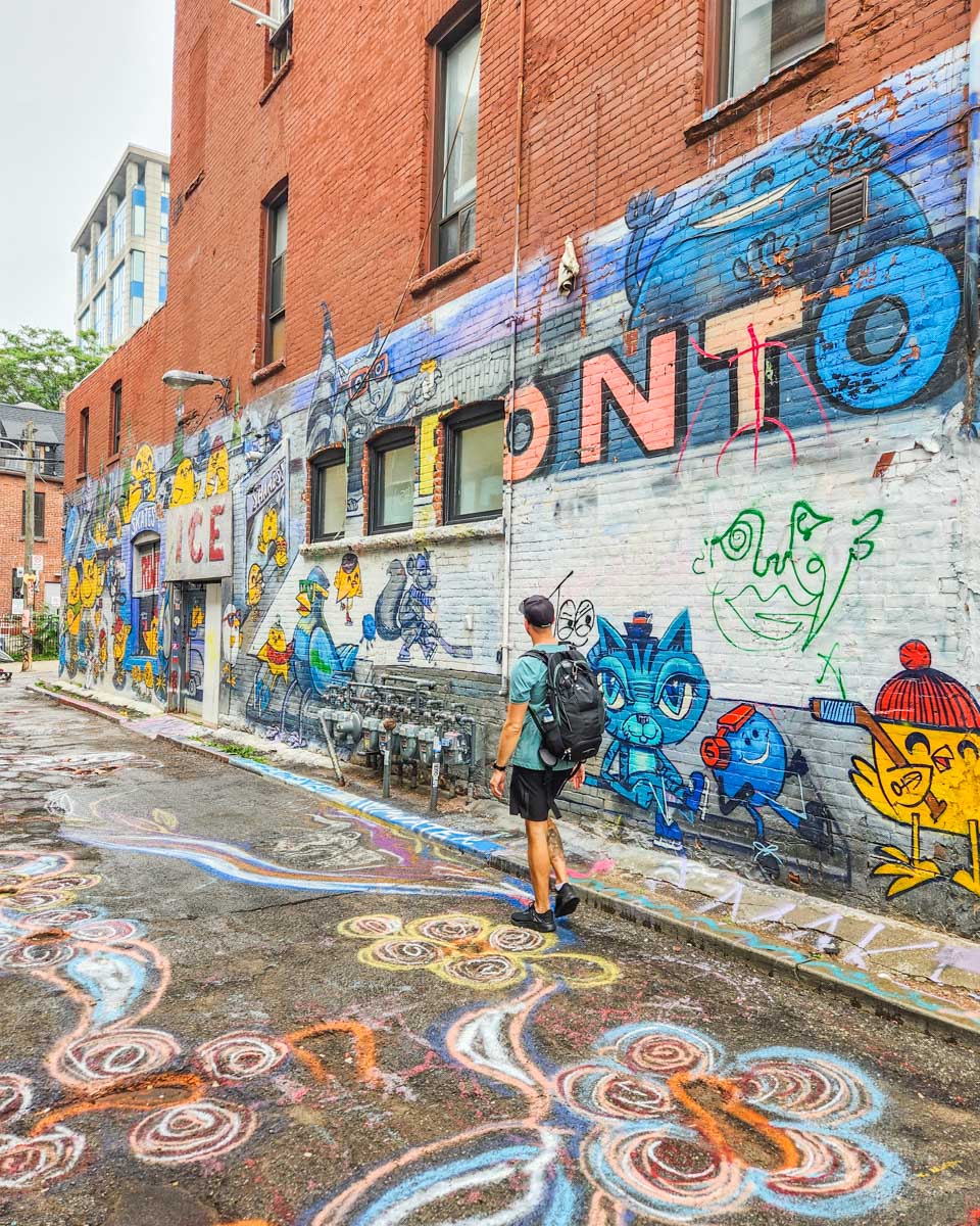 Daniel walks down Graffiti Alley in Toronto