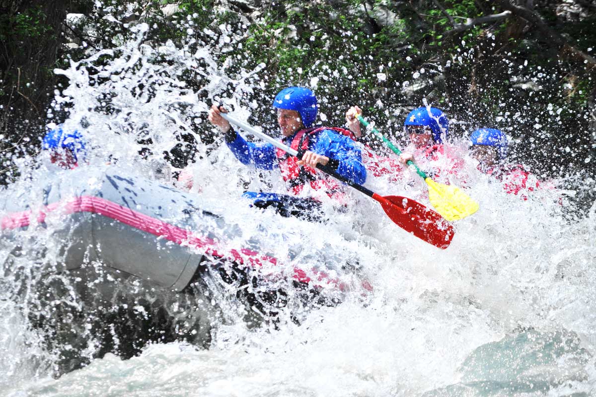 A group of people hit a rapid on a white water raft on the kicking Horse River in Canada