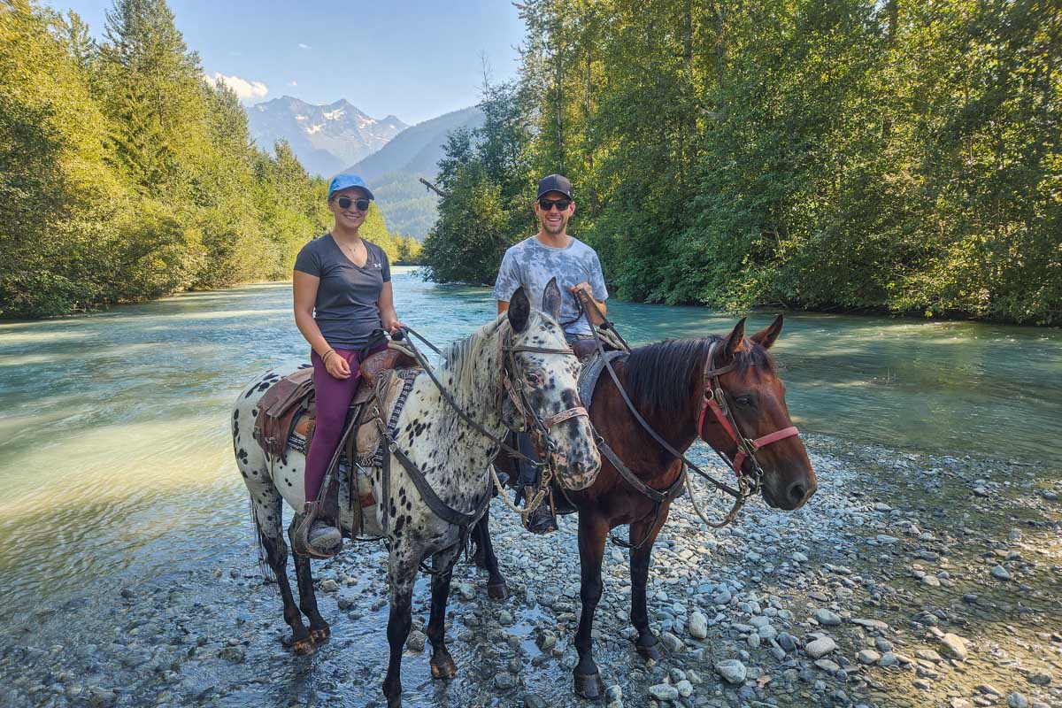 Daniel and Bailey pose with their horses in Banff National Park in the Spray River