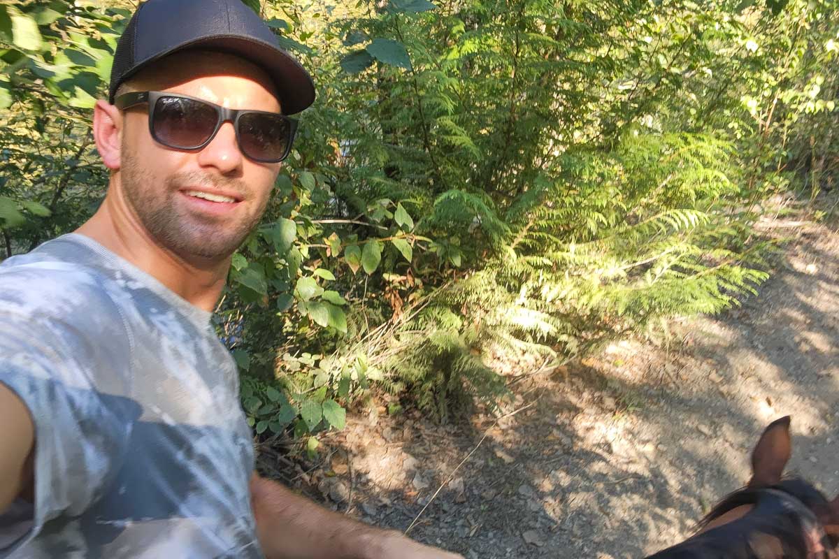 Daniel takes a selfie while riding a horse in Banff National Park, Canada