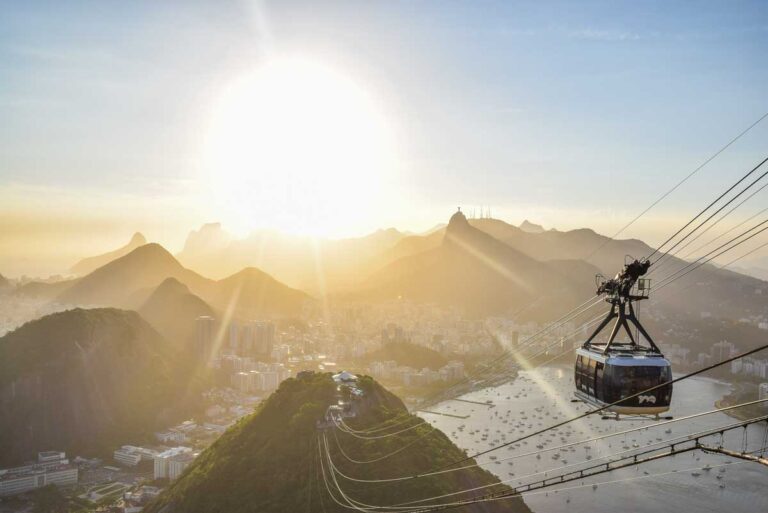 A cable car travels up Sugarloaf Mountain (Pão de Açúcar) in Rio de Janeiro, Brazil at sunset