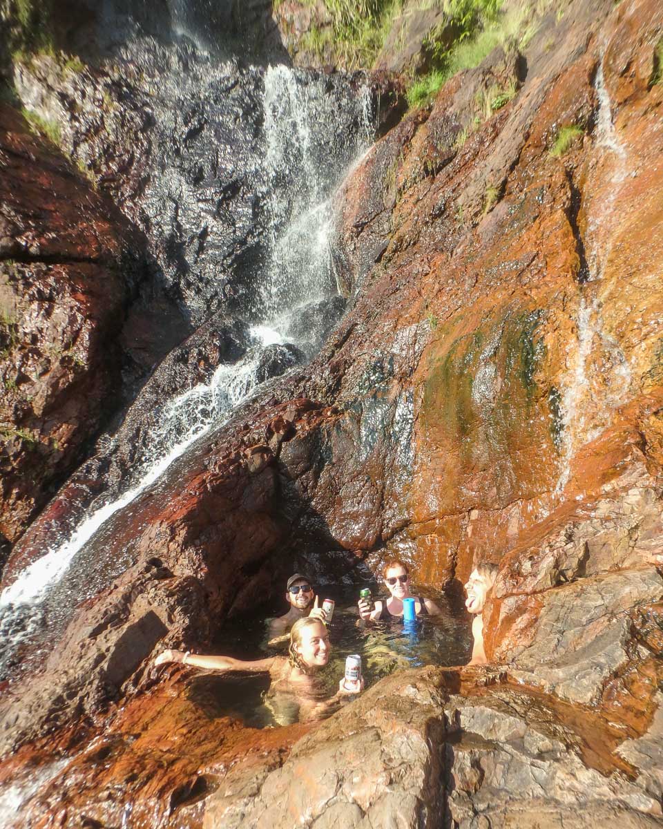 A group of people in the secret rock pool at Wangi Falls  