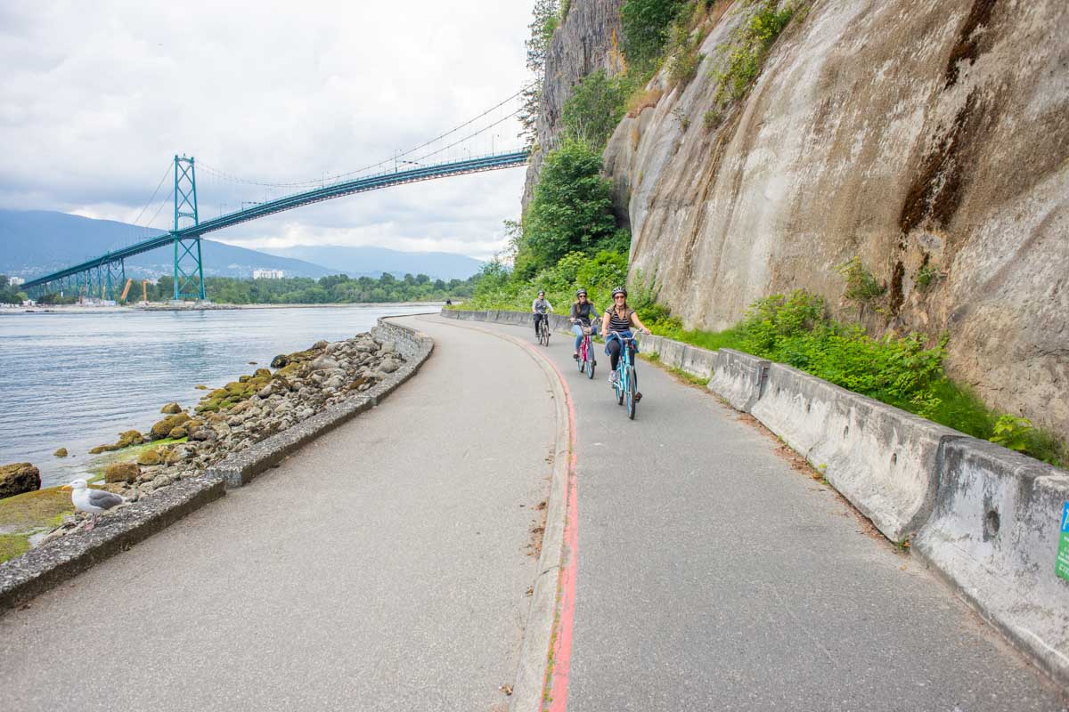 A group of people ride the Stanley Park seawall on a self guided tour
