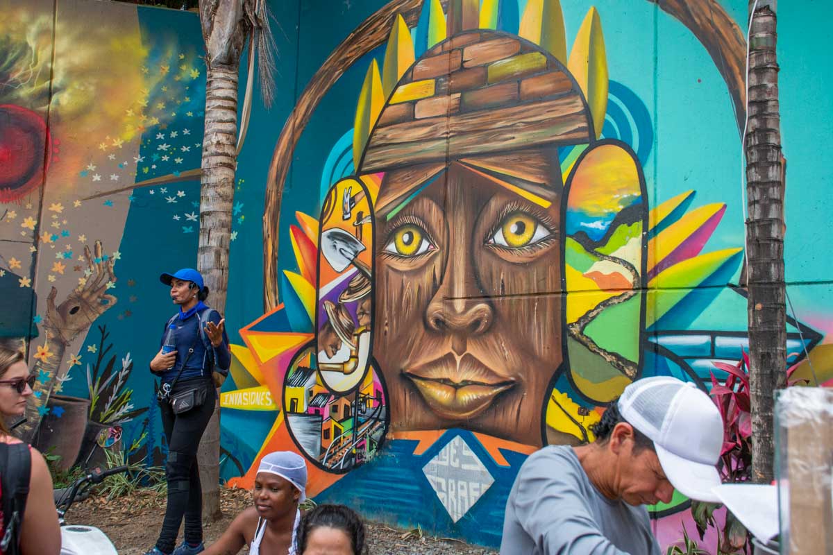 A local tour guide in Comuna 13 talks to a group of tourists