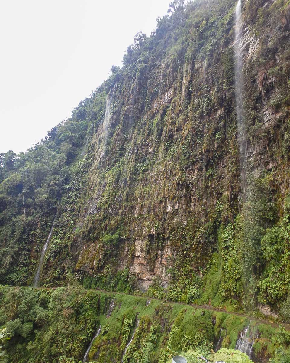 A thin path with waterfalls above on the Death Road in Bolivia